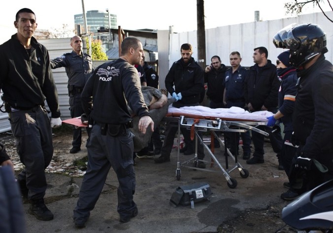 Israeli police officers carry on a stretcher a Palestinian man who stabbed up to 10 people in Tel Aviv
